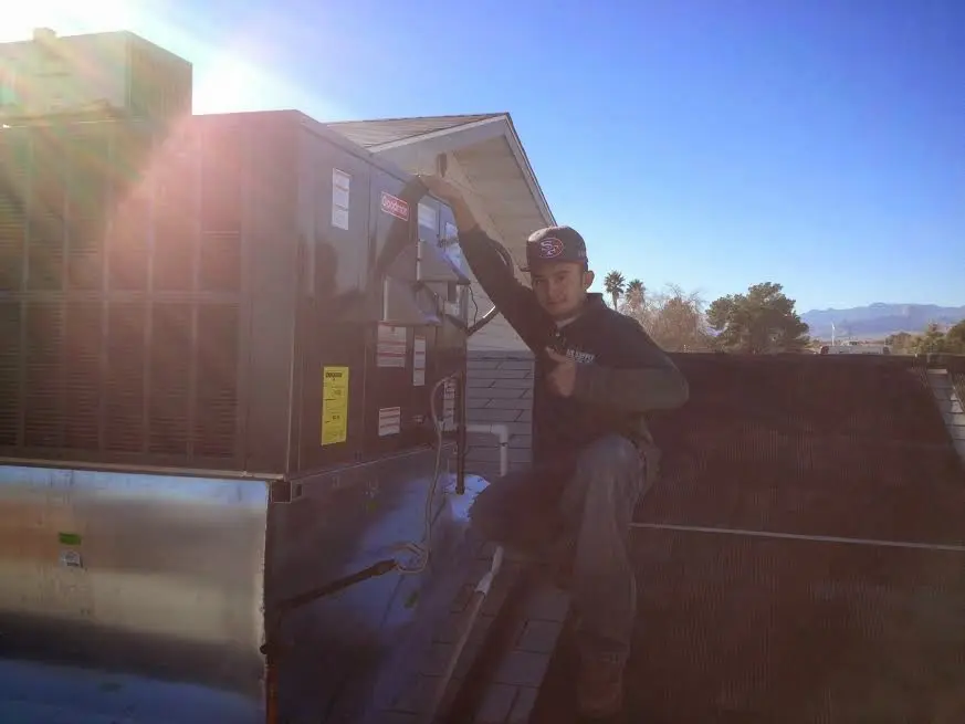 HVAC technician performing HVAC Inspection on a rooftop unit in Wells Branch